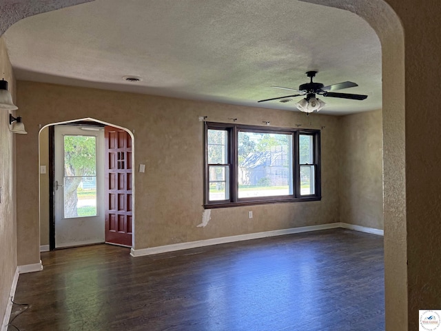 109 E Fairview St, Clinton, MO 64735 - foyer featuring dark wood-type flooring, a textured ceiling, arched walkways, and a ceiling fan