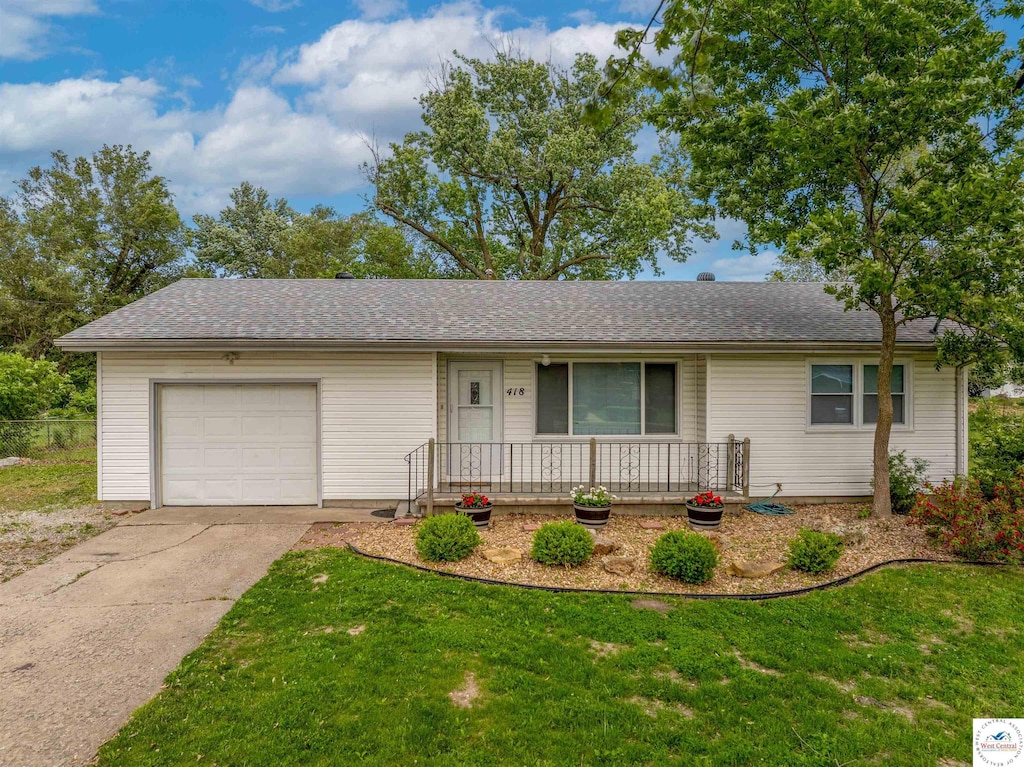 418 N Main St, La Monte, MO 65337 - ranch-style house with a porch, a garage, driveway, a front lawn, and roof with shingles