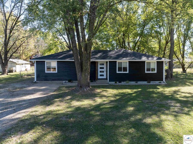 ranch-style home with fence, entry steps, and a front lawn