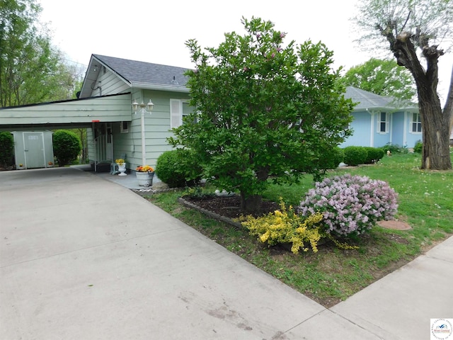 view of front of home with a carport, driveway, and roof with shingles