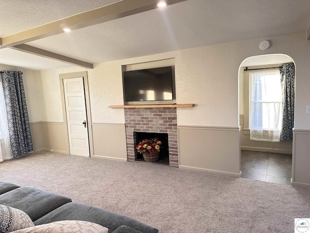 403 Van Buren St, Warsaw, MO 65355 - carpeted living area with a textured ceiling, beamed ceiling, baseboards, a brick fireplace, and wainscoting