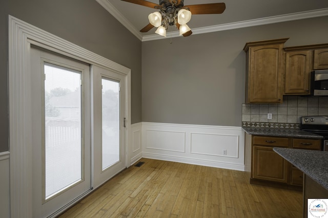 3415 Callaway Dr, Sedalia, MO 65301 - unfurnished dining area with light wood-style floors, a ceiling fan, ornamental molding, and wainscoting