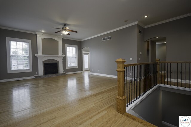 3415 Callaway Dr, Sedalia, MO 65301 - unfurnished living room with ceiling fan, plenty of natural light, crown molding, wood finished floors, and arched walkways