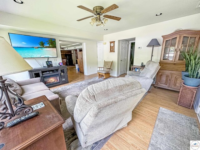 15157 Bass Rd, Gravois Mills, MO 65037 - living area featuring a glass covered fireplace, light wood-style flooring, ceiling fan, recessed lighting, and baseboards