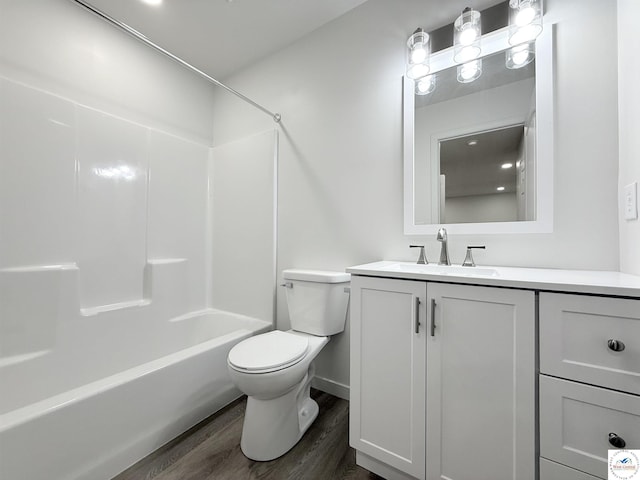 bathroom with tub / shower combination, baseboards, toilet, wood finished floors, and vanity