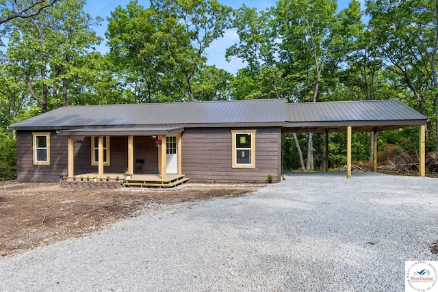 Gardiner Rd, Edwards, MO 65326 - view of front of home featuring a porch, an attached carport, gravel driveway, and metal roof