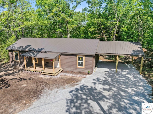 Gardiner Rd, Edwards, MO 65326 - view of front of house with driveway, an attached carport, a deck, and metal roof