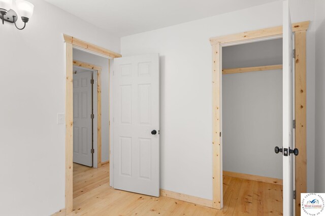 Gardiner Rd, Edwards, MO 65326 - unfurnished bedroom with light wood-type flooring, a closet, and baseboards