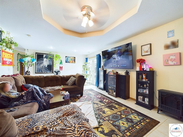 113 SE 1171st Rd, Knob Noster, MO 65336 - living room with light tile patterned floors, ceiling fan, a wood stove, and a raised ceiling