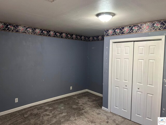 923 E Walnut St, Rich Hill, MO 64779 - unfurnished bedroom featuring a closet, a textured ceiling, carpet, and baseboards