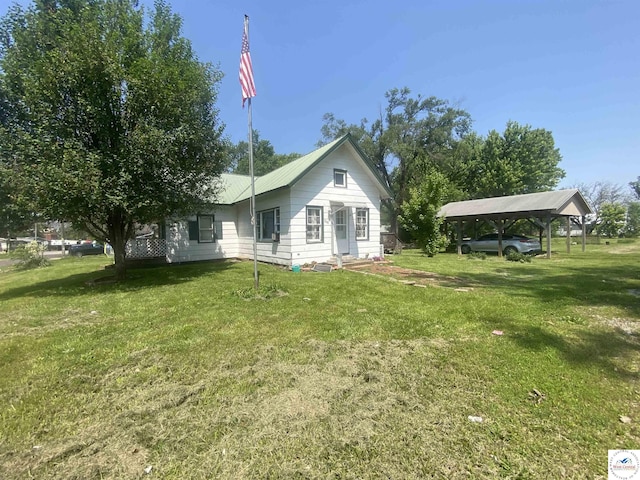 208 S Dixon, Lowry City, MO 64763 - view of home's exterior with a detached carport, a yard, and entry steps