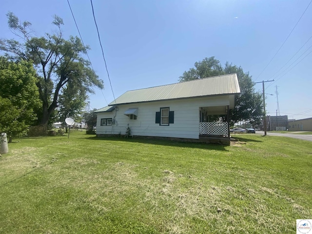 208 S Dixon, Lowry City, MO 64763 - view of home's exterior featuring a lawn and metal roof