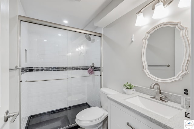 bathroom featuring vanity, toilet, and a shower stall