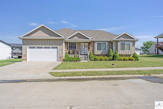 ranch-style home featuring a garage, a front yard, board and batten siding, a porch, and driveway