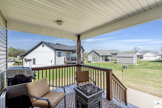 deck featuring a yard, a residential view, and a grill
