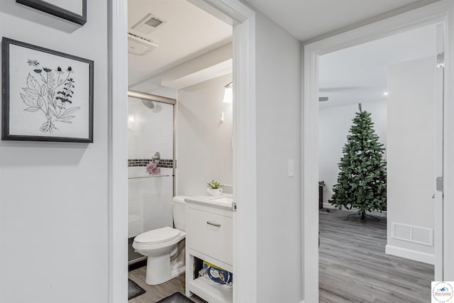 full bathroom featuring visible vents, a shower stall, wood finished floors, vanity, and toilet