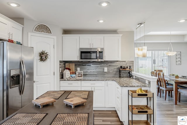 kitchen featuring decorative backsplash, light wood-style floors, stone countertops, white cabinets, and stainless steel appliances