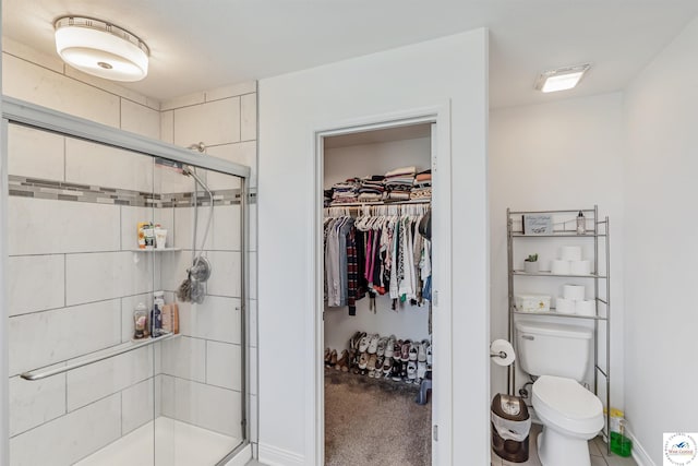 full bathroom with toilet, baseboards, a spacious closet, and a shower stall