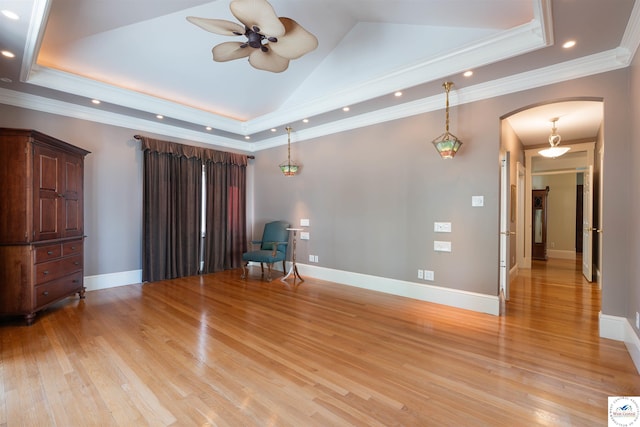 1114 W Broadway Blvd, Sedalia, MO 65301 - empty room featuring arched walkways, a ceiling fan, light wood-style flooring, a raised ceiling, and crown molding