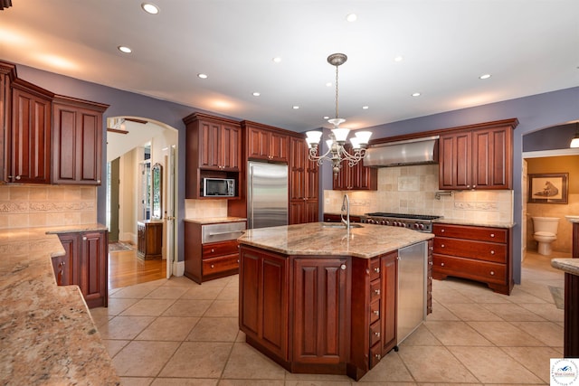 1114 W Broadway Blvd, Sedalia, MO 65301 - kitchen with wall chimney exhaust hood, stainless steel appliances, arched walkways, light tile patterned floors, and tasteful backsplash