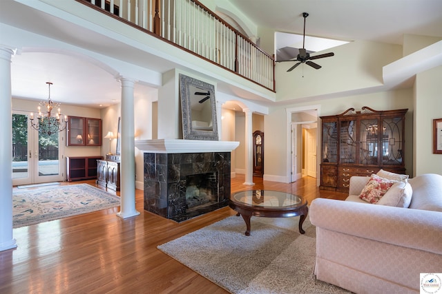 1114 W Broadway Blvd, Sedalia, MO 65301 - living room featuring ceiling fan, ornate columns, arched walkways, wood finished floors, and a tiled fireplace