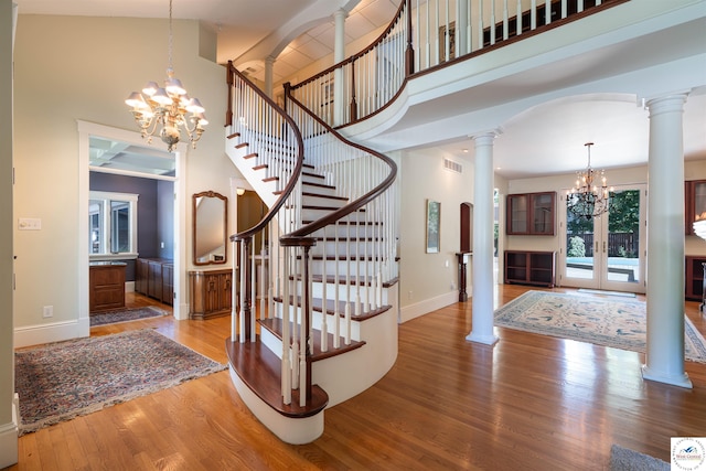 1114 W Broadway Blvd, Sedalia, MO 65301 - entryway featuring a chandelier, ornate columns, a towering ceiling, wood finished floors, and stairs