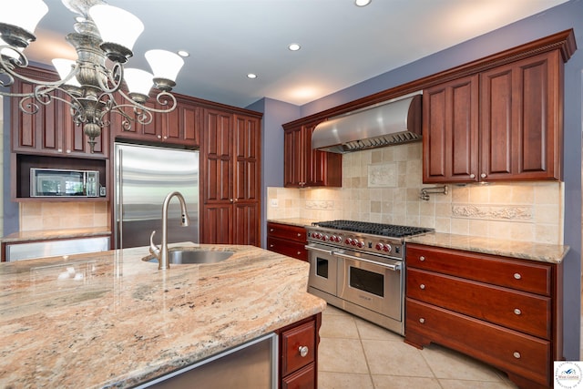 1114 W Broadway Blvd, Sedalia, MO 65301 - kitchen with high quality appliances, range hood, a chandelier, light tile patterned flooring, and recessed lighting