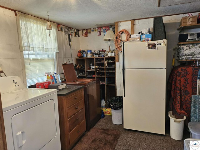 washroom with concrete block wall and washer / dryer