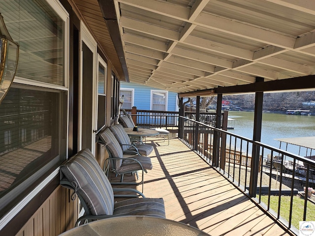 wooden deck with a boat dock and a water view