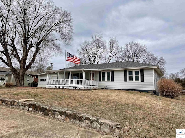 view of front of home with covered porch, an attached garage, and a front yard