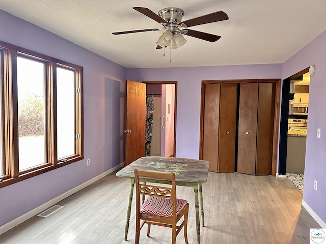 dining room with visible vents, light wood-style flooring, ceiling fan, and baseboards