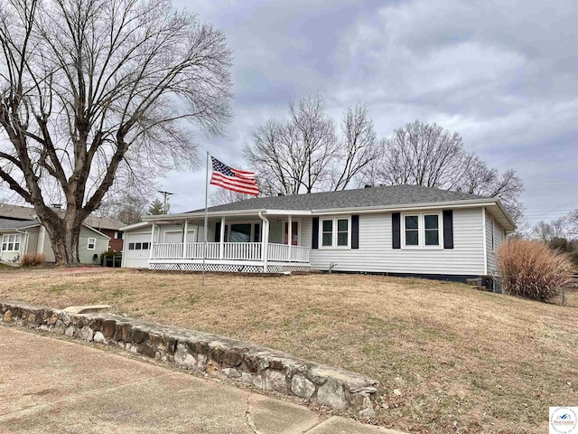 view of front of house featuring covered porch, a front yard, and a garage
