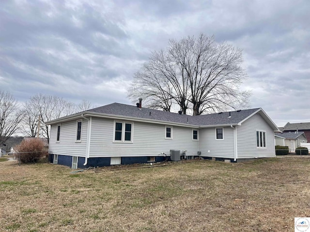 back of property with a lawn, roof with shingles, and cooling unit