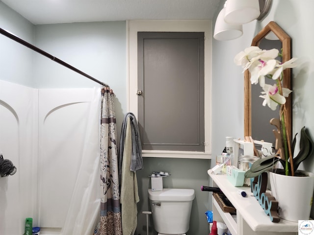 bathroom with toilet and curtained shower
