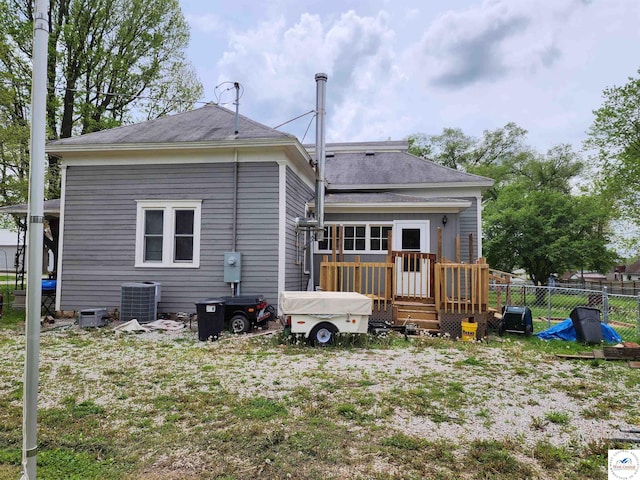 back of property with central air condition unit, a shingled roof, fence, and a deck