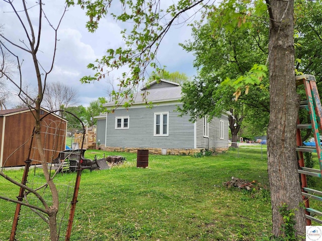 exterior space with a lawn, an outbuilding, and a storage shed