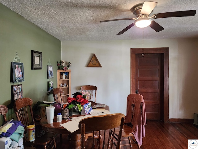 dining room with dark wood-type flooring, a textured ceiling, ceiling fan, and baseboards