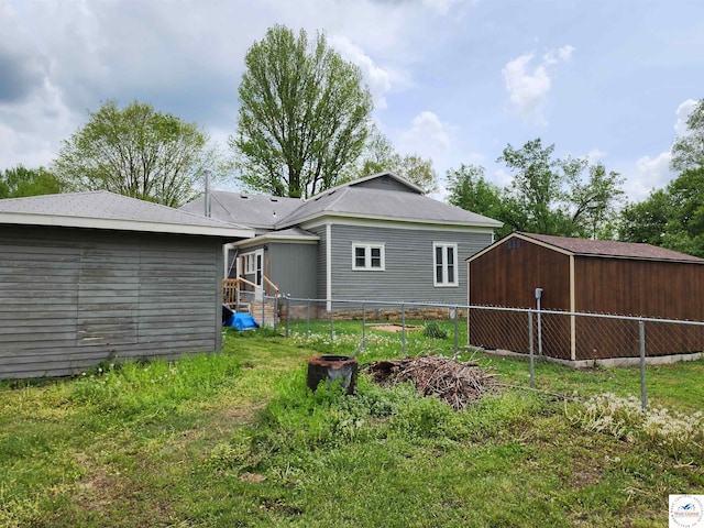 back of property featuring a storage shed, an outbuilding, and a fenced backyard