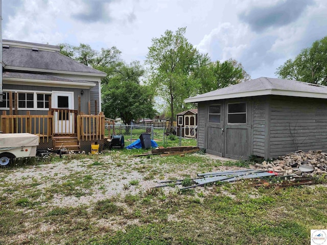 view of yard with a storage unit, fence, and an outbuilding