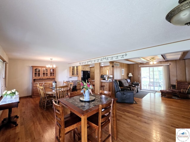 502 S Ferguson Ave, Tipton, MO 65081 - dining area with visible vents, wood finished floors, and ceiling fan with notable chandelier