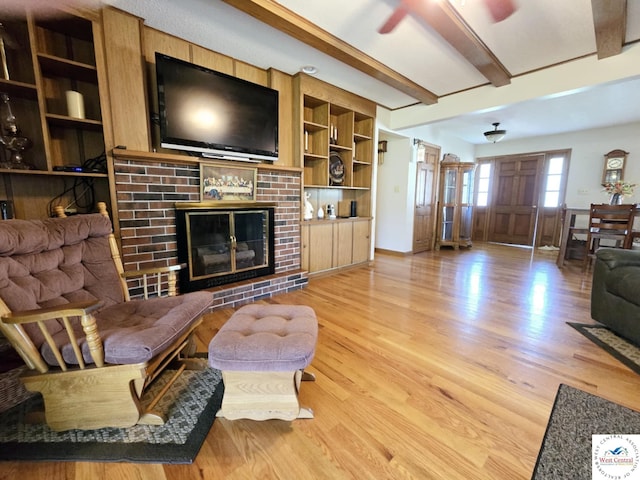 502 S Ferguson Ave, Tipton, MO 65081 - living room with a fireplace, a ceiling fan, beam ceiling, and light wood-style floors