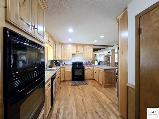 502 S Ferguson Ave, Tipton, MO 65081 - kitchen with light brown cabinetry, a sink, recessed lighting, light wood-type flooring, and black appliances