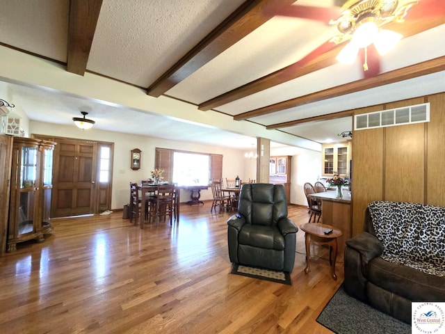 502 S Ferguson Ave, Tipton, MO 65081 - living area with visible vents, a ceiling fan, wood finished floors, and beamed ceiling