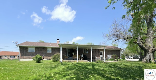502 S Ferguson Ave, Tipton, MO 65081 - rear view of house featuring brick siding, a patio area, a yard, and a chimney