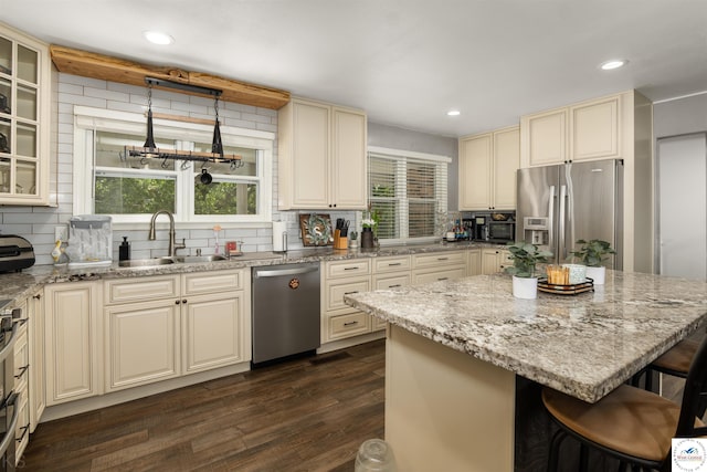 321 E 17th St, Sedalia, MO 65301 - kitchen with appliances with stainless steel finishes, a sink, cream cabinetry, decorative backsplash, and recessed lighting