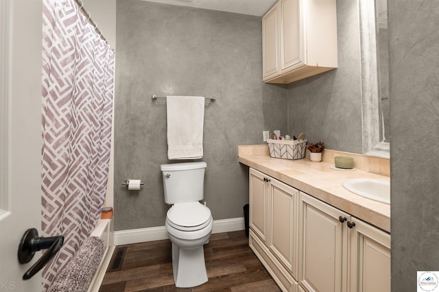 321 E 17th St, Sedalia, MO 65301 - bathroom with wood finished floors, toilet, vanity, baseboards, and shower / bath combo