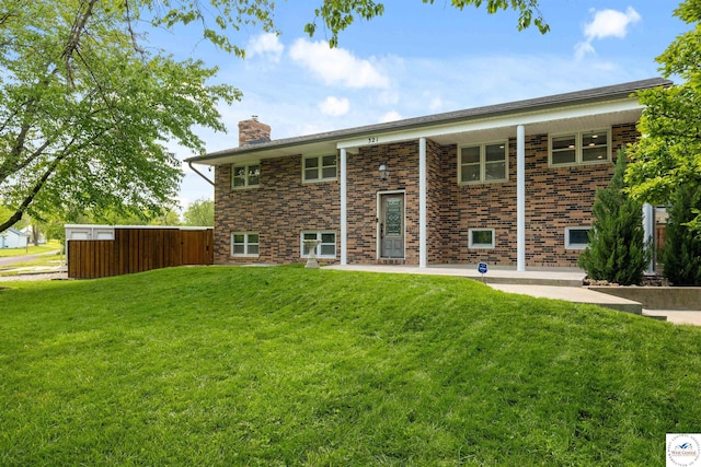 321 E 17th St, Sedalia, MO 65301 - rear view of property featuring a chimney, a lawn, and brick siding