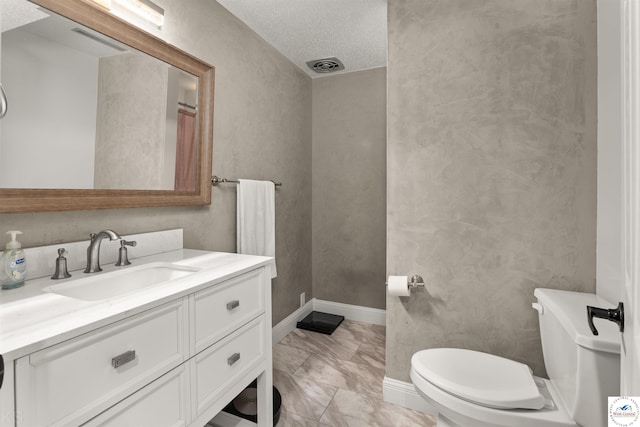 321 E 17th St, Sedalia, MO 65301 - bathroom with toilet, vanity, marble finish flooring, baseboards, and a textured ceiling