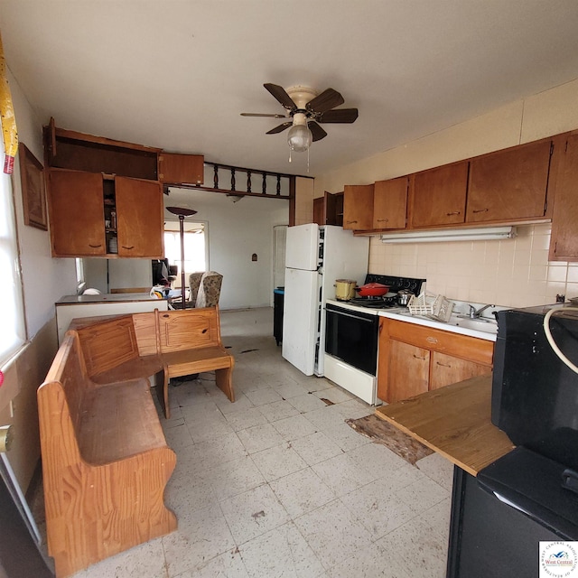 kitchen featuring decorative backsplash, ceiling fan, electric range oven, light floors, and brown cabinetry