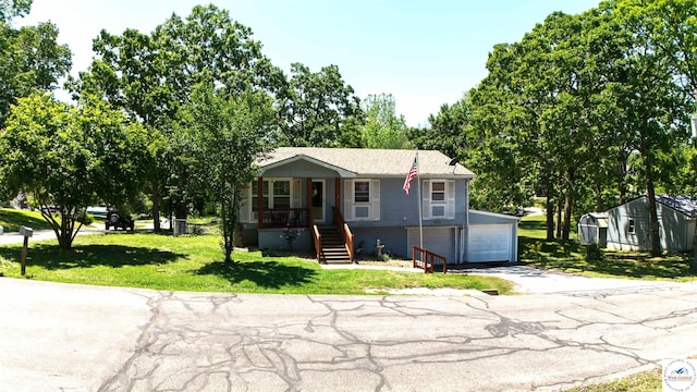 715 Hickory St, Warsaw, MO 65355 - view of front of home featuring a garage, covered porch, driveway, stairs, and a front yard